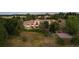 Aerial view of the home's expansive backyard with a fire pit and sports court amidst lush greenery at 11541 Warrington Ct, Parker, CO 80138