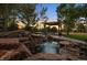 Landscaped backyard featuring a serene rock waterfall and a charming gazebo with outdoor seating at 11541 Warrington Ct, Parker, CO 80138