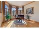 Sun-filled bonus room featuring a Kawai piano, hardwood floors, and large windows at 11541 Warrington Ct, Parker, CO 80138