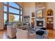 Bright living room with tall ceilings, fireplace, large windows offering scenic views, and plush seating at 11541 Warrington Ct, Parker, CO 80138