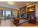 Cozy living room features a stone fireplace, built-in shelves, and scenic views from large windows at 11541 Warrington Ct, Parker, CO 80138