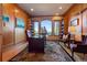 Wood-paneled office with built-in bookshelves, a large desk, and scenic views from the large windows at 11541 Warrington Ct, Parker, CO 80138