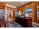 Elegant office with wood paneling, built-in shelving, and glass doors that open to an adjacent room at 11541 Warrington Ct, Parker, CO 80138