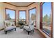 Bright sitting room with comfortable chairs and large windows showcasing scenic views at 11541 Warrington Ct, Parker, CO 80138