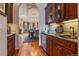 Custom wet bar with wine refrigerator and dining room beyond an arched entryway at 11541 Warrington Ct, Parker, CO 80138