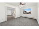 A bright bedroom with neutral carpet, modern ceiling fan, and large window with neighborhood view at 3022 S Wheeling Way # 109, Aurora, CO 80014