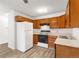 Cozy kitchen featuring wood cabinets, white appliances, and practical layout at 3022 S Wheeling Way # 109, Aurora, CO 80014