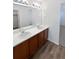 Bathroom with double vanity, updated fixtures, and wood-look flooring at 25643 E Bayaud Ave, Aurora, CO 80018