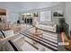 Virtually staged living room features a white sofa and striped rug at 25643 E Bayaud Ave, Aurora, CO 80018