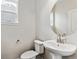 Modern half-bathroom featuring a pedestal sink, round mirror and toilet with light walls at 2536 Wesley Ln, Lafayette, CO 80026