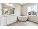 Bathroom with a standing tub and white vanity with a large mirror and tiles floors at 2536 Wesley Ln, Lafayette, CO 80026