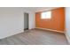 Neutral room has an orange accent wall, window and closet at 7335 E Quincy Ave # 104, Denver, CO 80237