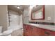 This bathroom features a bathtub with shower, storage shelves, and a vanity with solid surface countertops at 3906 S Quemoy Ct, Aurora, CO 80018