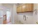 Laundry room with tile floor and upper wooden cabinets for storage at 3906 S Quemoy Ct, Aurora, CO 80018