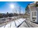 Spacious deck with snow and a view of a wooded area at 60 Golden Eagle Rd, Greenwood Village, CO 80121