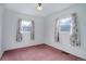 Bright bedroom with two windows, featuring a vintage light fixture and salmon colored carpeting at 4850 E 18Th Ave, Denver, CO 80220