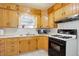 A quaint kitchen with wood cabinets, white tile backsplash, and essential appliances at 4850 E 18Th Ave, Denver, CO 80220