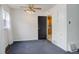 This living room features blue carpet, a dark paneled doorway, and a ceiling fan at 4850 E 18Th Ave, Denver, CO 80220