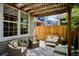 Cozy back patio with comfortable wicker seating and a charming pergola for outdoor relaxation at 2723 Galena St, Denver, CO 80238