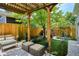 Charming backyard with a pergola, a lush lawn, well-manicured landscaping, and a stone patio at 2723 Galena St, Denver, CO 80238