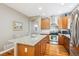 Open kitchen with wood cabinets, granite countertops, stainless steel appliances and center island with barstool seating at 2723 Galena St, Denver, CO 80238