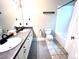 Bathroom featuring dual sinks, new plumbing fixtures, ample counter space, and updated flooring at 7429 S Alkire St # 205, Littleton, CO 80127