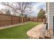 Fenced backyard with artificial turf and stone walkway at 9807 Arthur Ln, Highlands Ranch, CO 80130