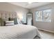 Bright bedroom featuring a comfortable bed with a tufted headboard and a large window at 9807 Arthur Ln, Highlands Ranch, CO 80130