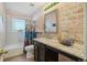 Bathroom with a brick accent wall, a vanity with a granite counter, and tiled floors at 25123 E 5Th Ave, Aurora, CO 80018