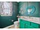 Stylish bathroom with a green vanity, granite countertop, and a unique mosaic-framed mirror at 25123 E 5Th Ave, Aurora, CO 80018