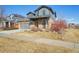 Well-maintained home features a stone facade, covered porch, and landscaped front yard at 25123 E 5Th Ave, Aurora, CO 80018