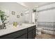 Bathroom with a single sink vanity, decorative shower curtain and tiled floor at 26787 E Maple Ave, Aurora, CO 80018