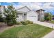 Well-maintained home showcasing a front yard, a two-car garage, and a covered porch with blue skies above at 26787 E Maple Ave, Aurora, CO 80018