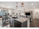 Open concept kitchen with an island, bar seating, and an adjacent dining area leading to the outdoor patio at 26787 E Maple Ave, Aurora, CO 80018