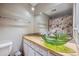 Modern bathroom boasts a green glass vessel sink and wood countertop at 12173 W 27Th Dr, Lakewood, CO 80215
