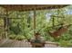 Outdoor seating area with two swing chairs, table with plants, and view of surrounding trees at 12173 W 27Th Dr, Lakewood, CO 80215