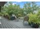 Large deck space with a grill and dining area surrounded by lush greenery at 12173 W 27Th Dr, Lakewood, CO 80215