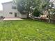 Expansive backyard with green grass, concrete patio, and a wooden fence perimeter at 21767 Silver Meadow Ln, Parker, CO 80138