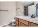 Simple and functional bathroom features a wood vanity, toilet, and a shower with gray tiles at 21767 Silver Meadow Ln, Parker, CO 80138