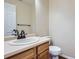 Clean and simple bathroom featuring a wood vanity with a large mirror and a toilet at 21767 Silver Meadow Ln, Parker, CO 80138