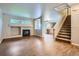 Open-concept living room featuring a cozy fireplace, hardwood floors, and staircase at 21767 Silver Meadow Ln, Parker, CO 80138