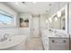 Bright bathroom features a soaking tub, marble countertop with double sinks, and modern lighting at 2683 Bellaire St, Denver, CO 80207