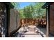 Outdoor patio featuring a brick fire pit with seating, set against a charming fence backdrop at 2683 Bellaire St, Denver, CO 80207