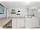 Functional laundry area with washer, dryer, ample counter space, and storage cabinets at 2683 Bellaire St, Denver, CO 80207