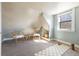 Sunlit finished attic features two chairs, a yoga mat, window, and slanted ceilings at 3147 Umatilla St, Denver, CO 80211