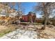Large backyard with a patio set, garden, red exterior walls, and mature trees at 3147 Umatilla St, Denver, CO 80211