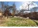 Backyard with lush green grass, trees, a shed, and a wooden fence at 3147 Umatilla St, Denver, CO 80211