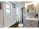 Updated bathroom featuring a classic tub and shower, stylish vanity, and refinished hardwood floor at 3147 Umatilla St, Denver, CO 80211