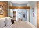 Stylish bedroom featuring exposed brick, light blue walls, and an open closet concept at 3147 Umatilla St, Denver, CO 80211