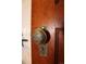 Close-up of vintage doorknob with intricate detailing on a dark stained wood door at 3147 Umatilla St, Denver, CO 80211